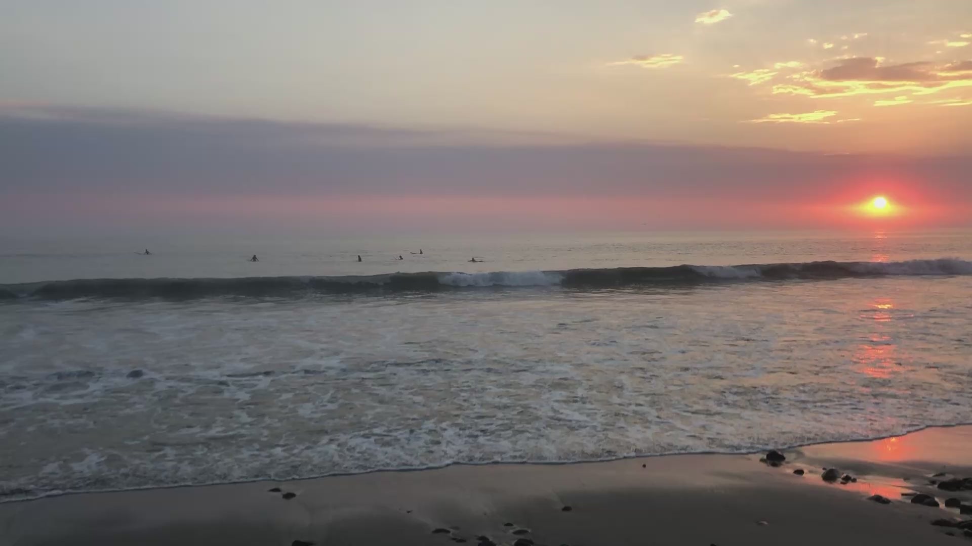Load video: Family at beach surfing at sunset